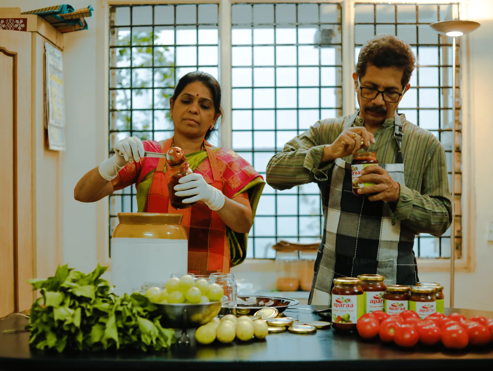 The Aparaa founders filling jars of pickle in their kitchen